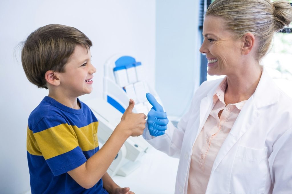 Happy dentist playing with boy